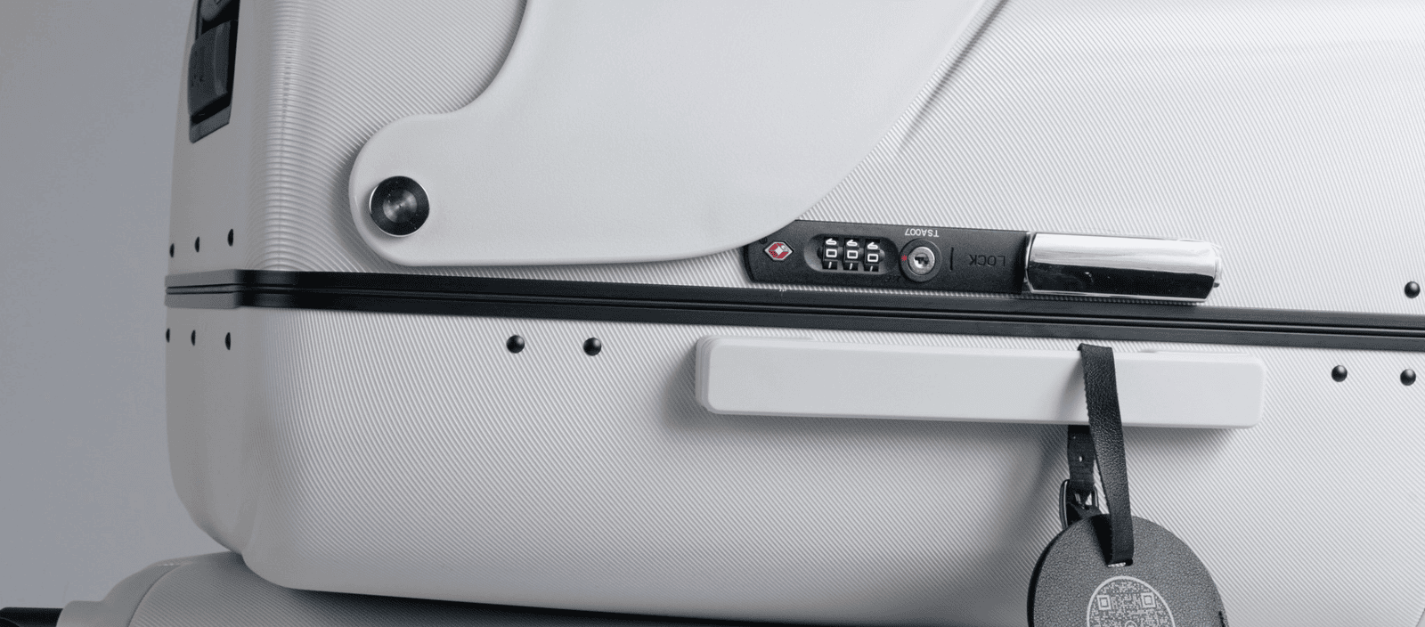 Flight luggage with digital lock and luggage tag on white textured suitcase.