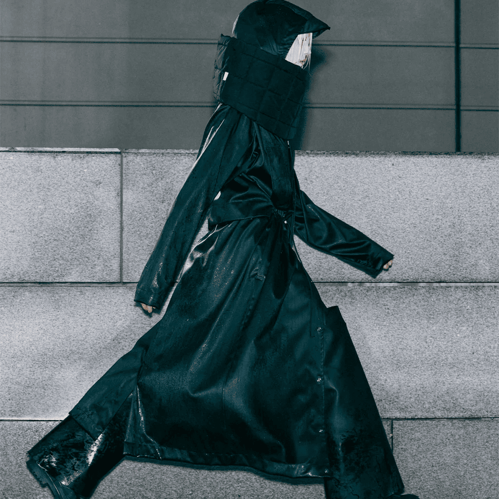 Black fashion coat with hood and rain-resistant material for urban street style.