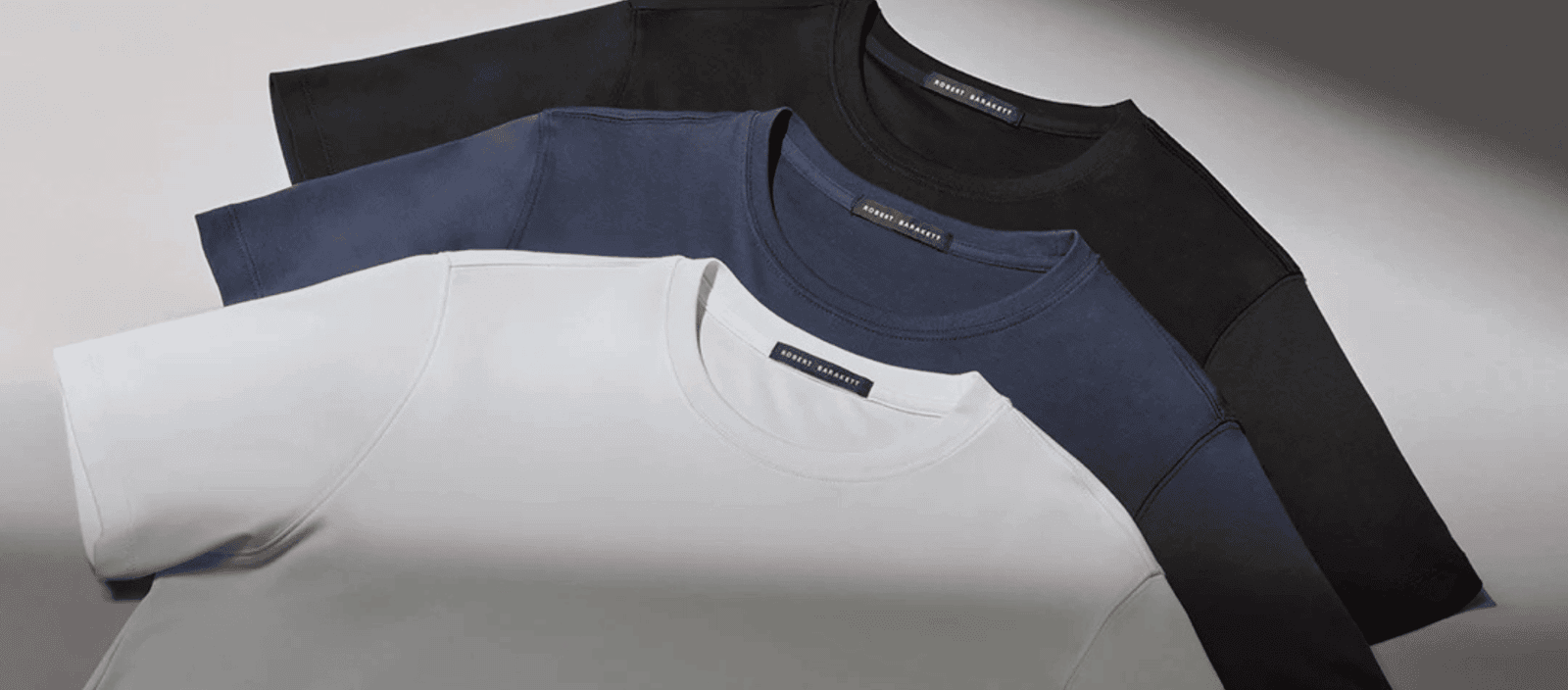 Plain crewneck t-shirts in black, navy, and white, laid flat for a minimalistic, stylish look.