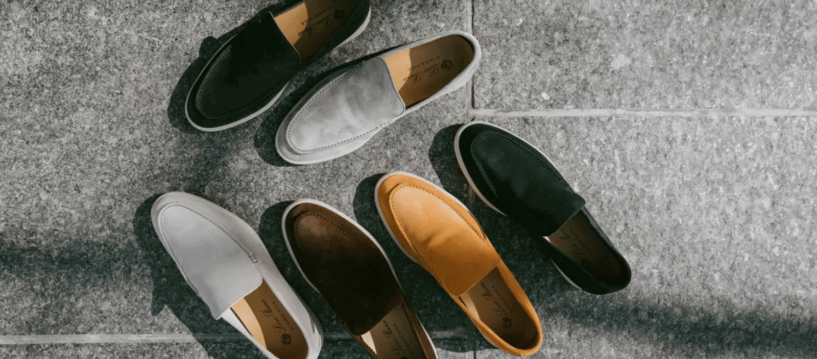 Colorful casual loafers on a textured concrete surface.