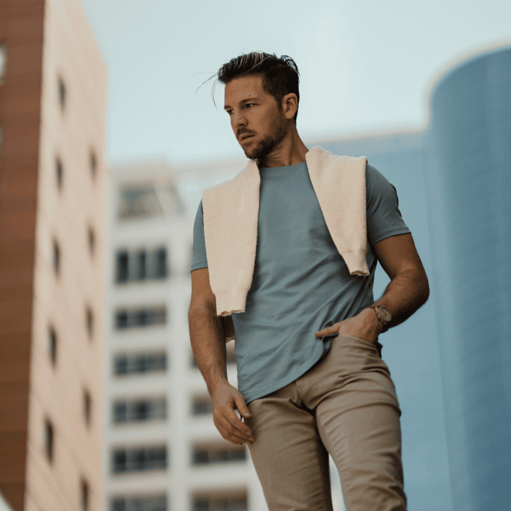 Relaxed male model wearing casual menswear in urban setting, showcasing modern fashion style.
