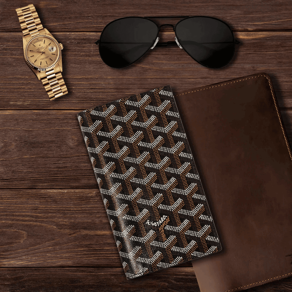 Luxury patterned wallet on wooden surface with sunglasses and watch.