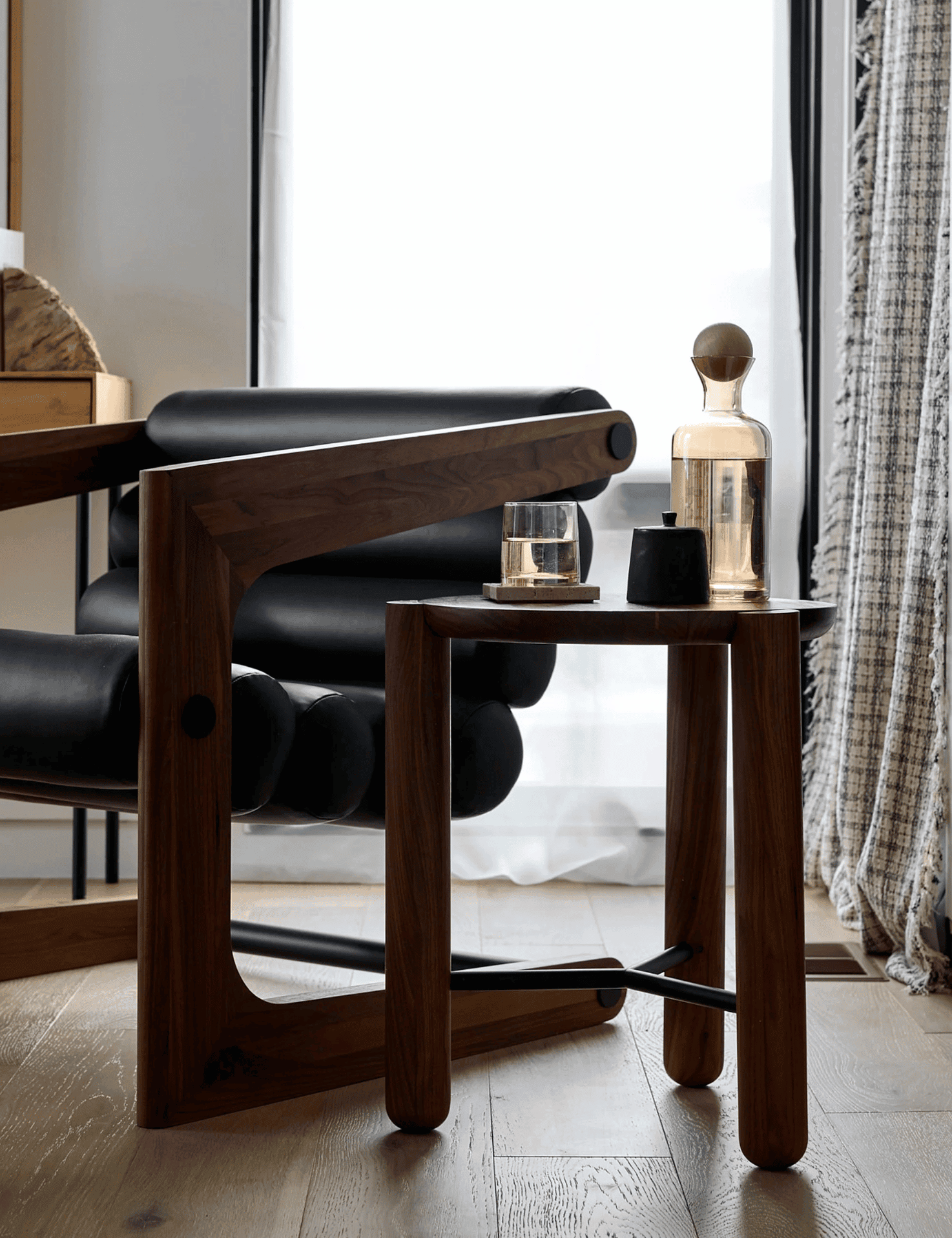 Modern wooden side table with decorative glass vases and candles in a cozy living space.