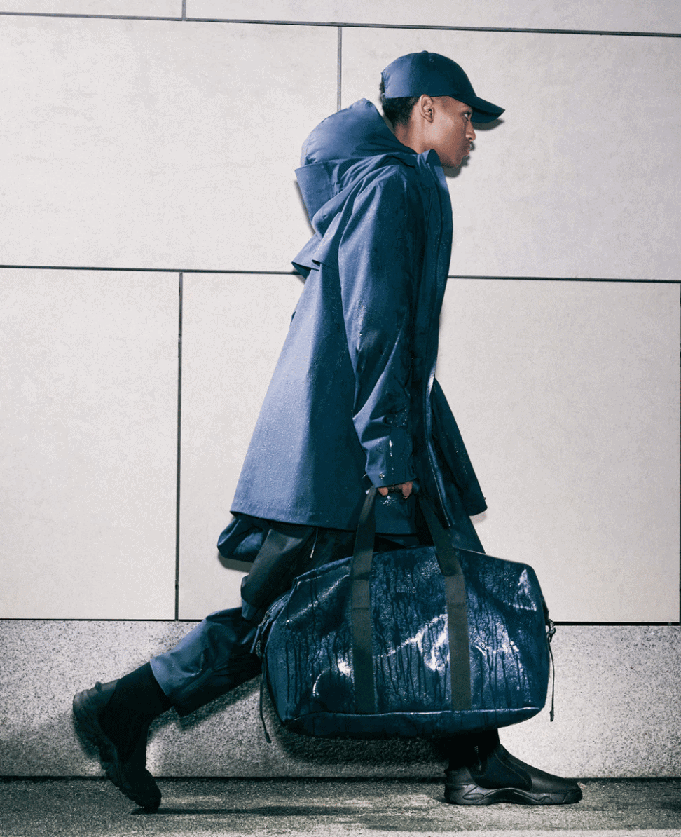 Waterproof rain jacket and duffle bag for travel or outdoor activities, stylish and functional, perfect for urban commuting and weather protection.
