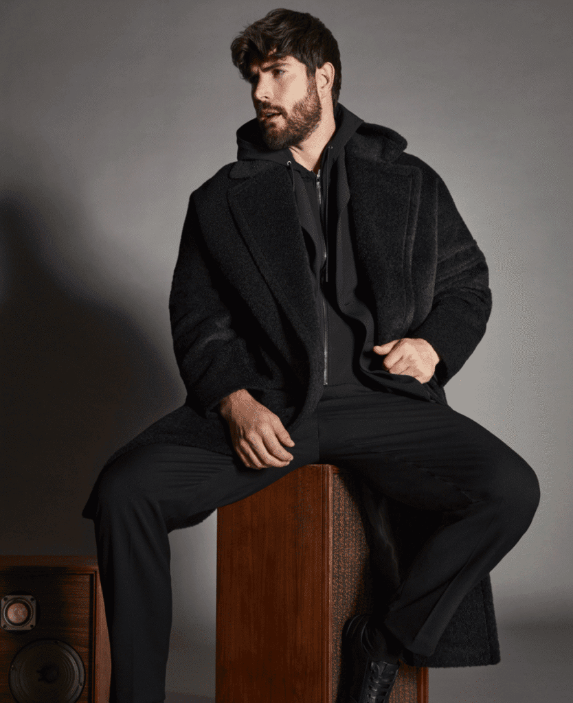 Fur-lined men's winter coat for cold weather, stylish and warm outerwear, black, with hood and zipper closure.