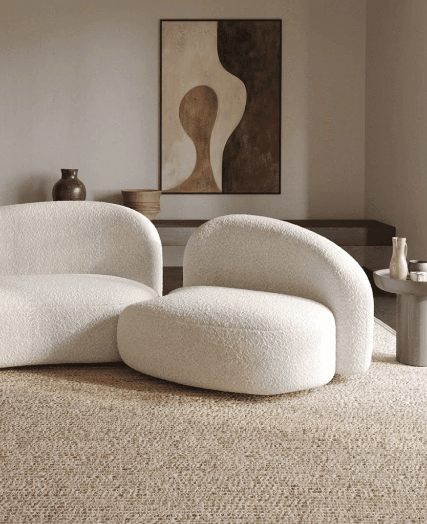 Soft modern cream upholstered sofa with textured fabric in stylish minimalist living room.