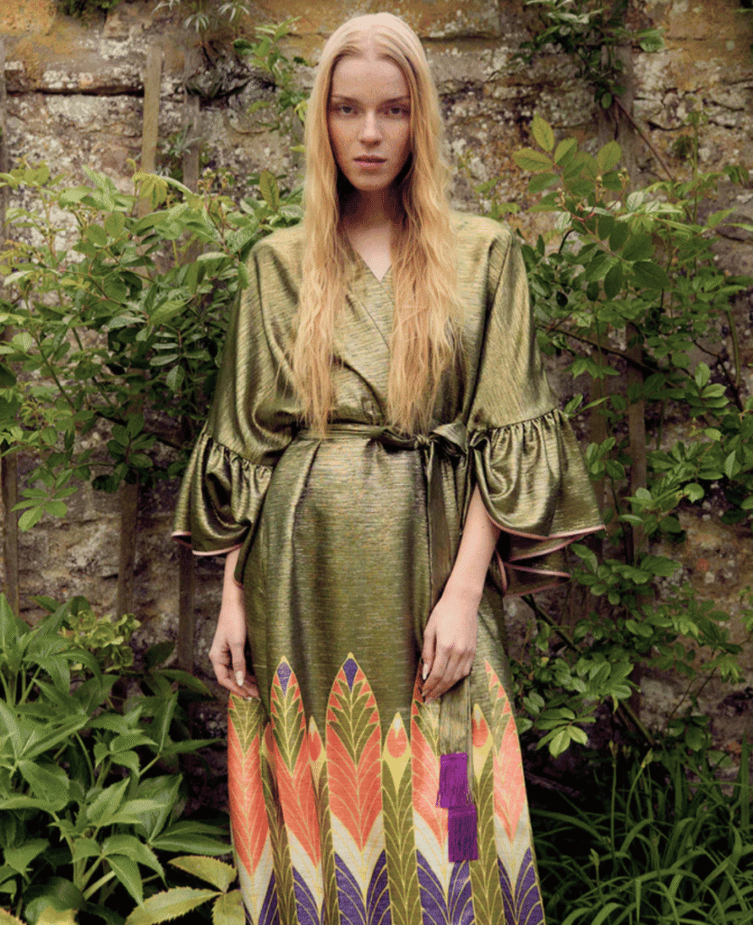 Green metallic dress with puffed sleeves and colorful feather pattern at the hem, outdoor setting at lushcollective.com.