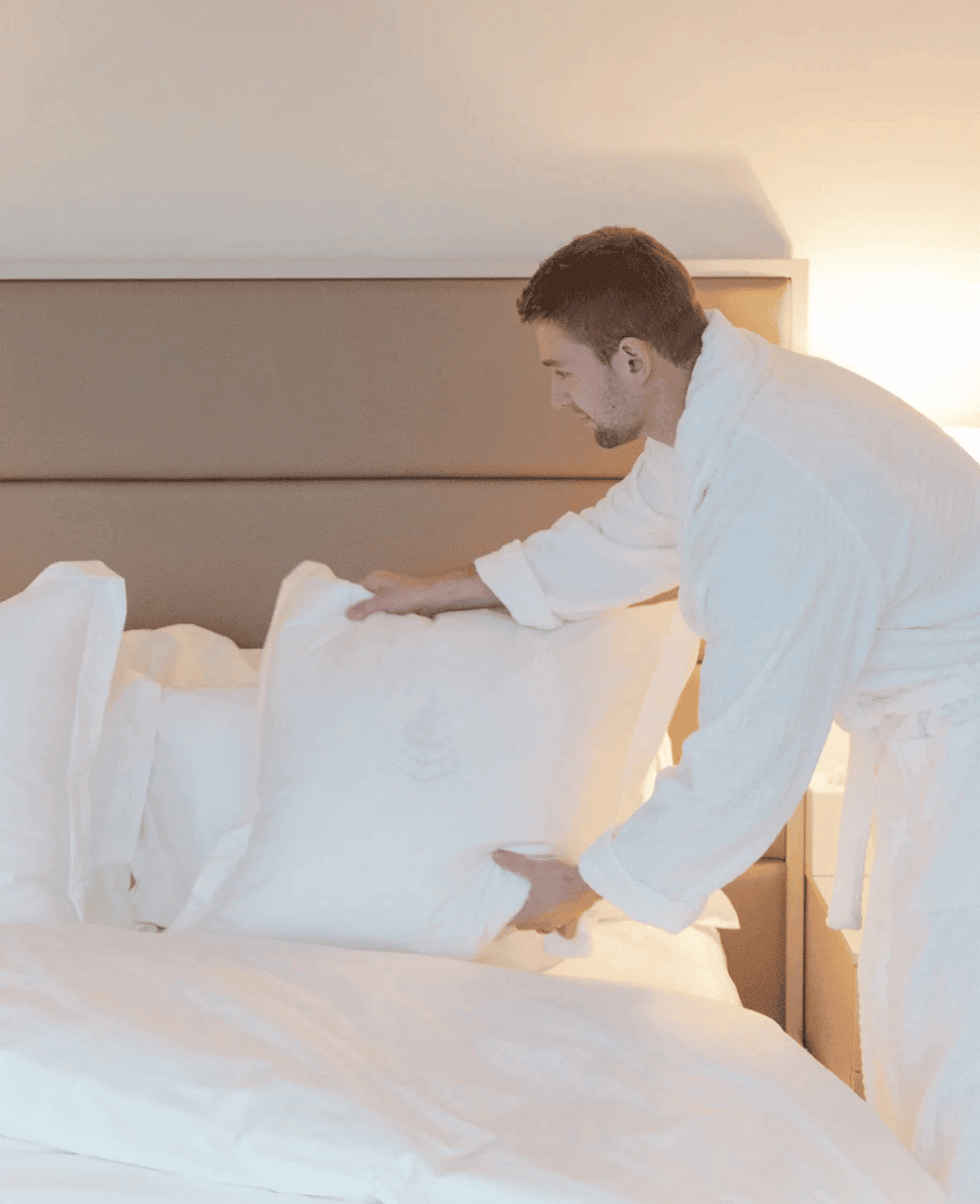 Luxury hotel bedding and pillow arrangement, relaxing morning routine at a hotel, hotel room with white linens and modern decor.