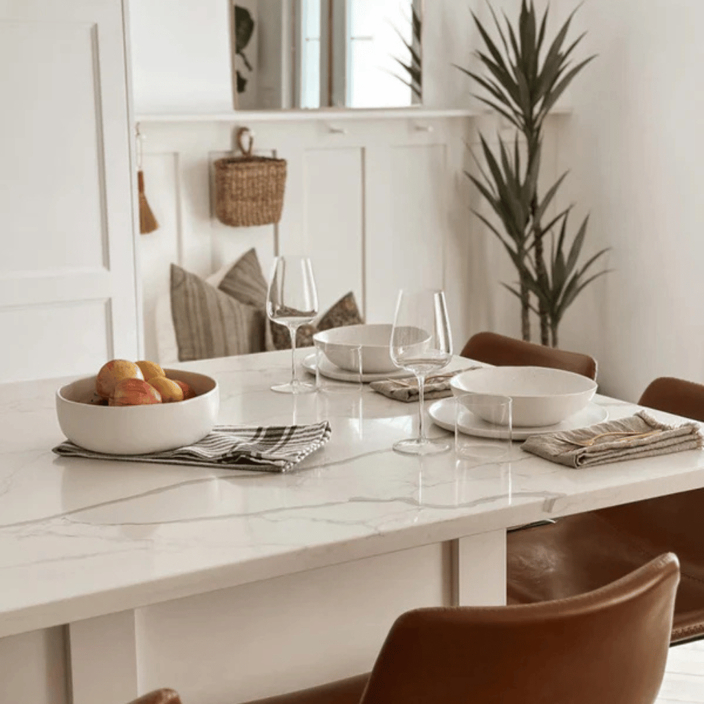 Cozy dining room with marble table and modern decor, minimalist style, natural light, neutral tones, lush interior design.