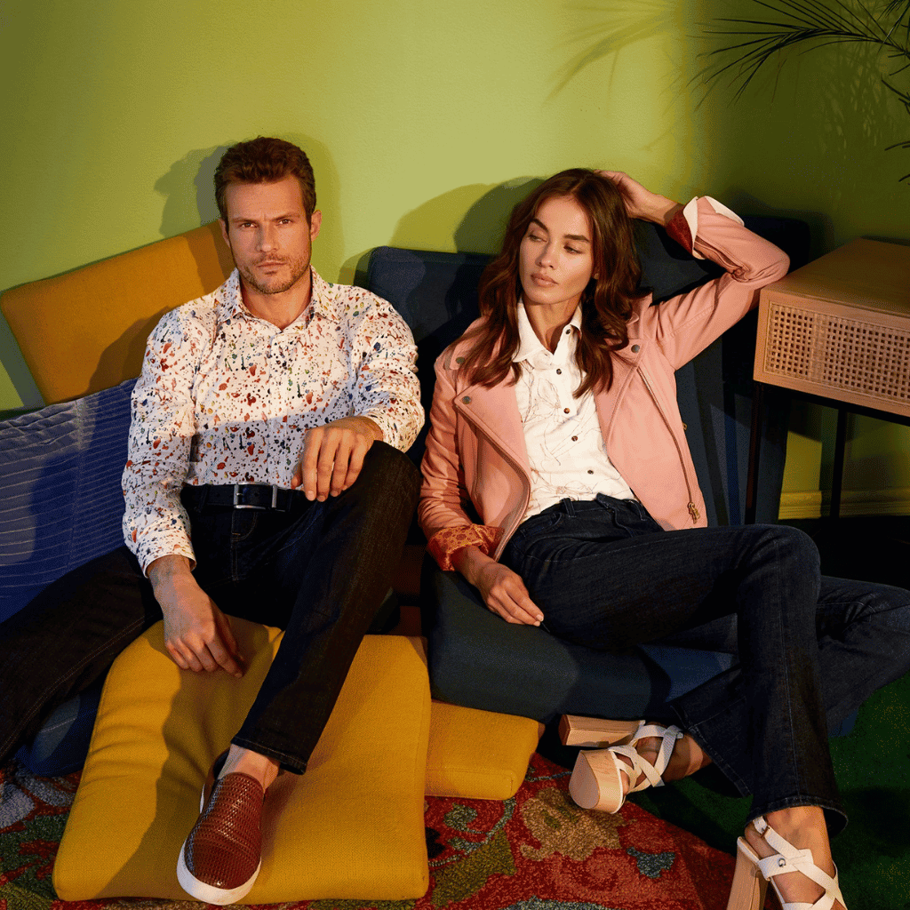 Relaxed young couple lounging with colorful decor in modern interior for lifestyle shooting.