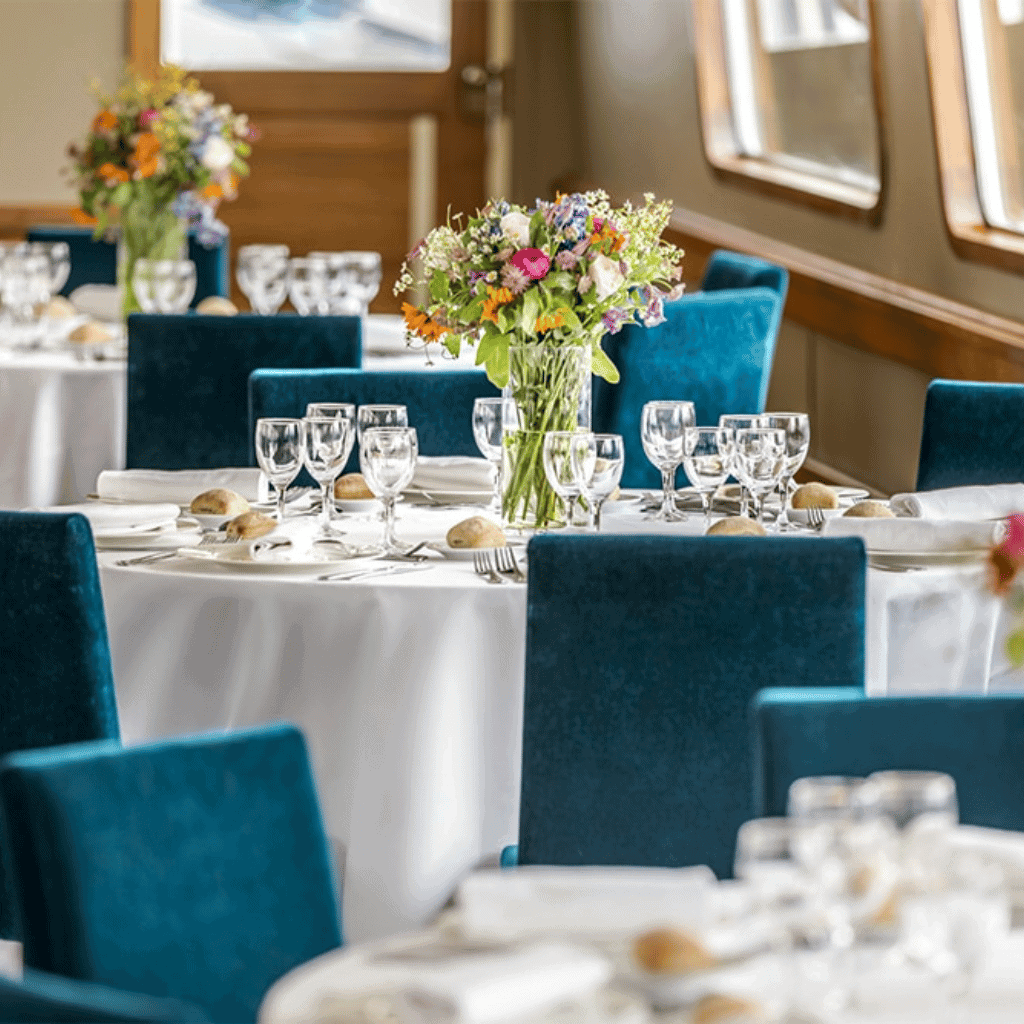 Luxury event table setting with floral centerpiece and elegant glassware.