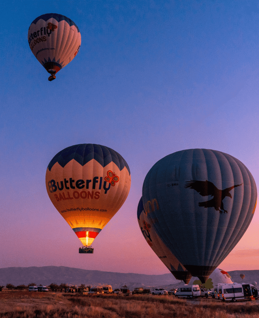 Hot air balloons soaring at sunrise over open field, vibrant colors, scenic outdoor adventure.