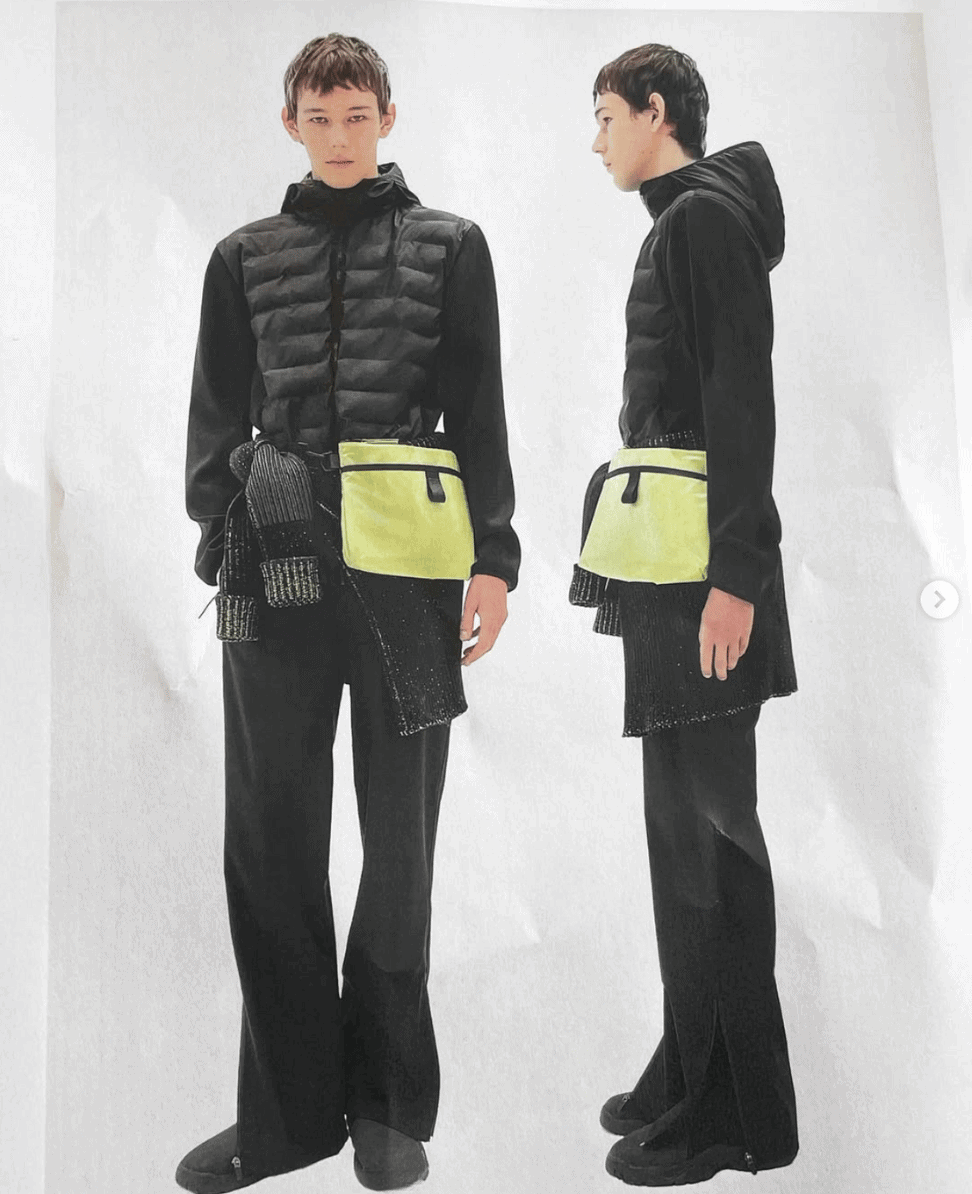 Puffer vest with reflective accents, black hoodie, wide-leg pants, fashion-forward outdoor wear.