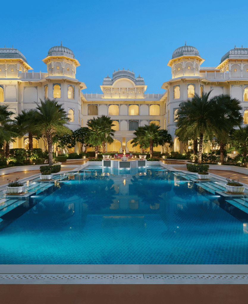 Luxurious hotel with grand architecture and a stunning pool at dusk.