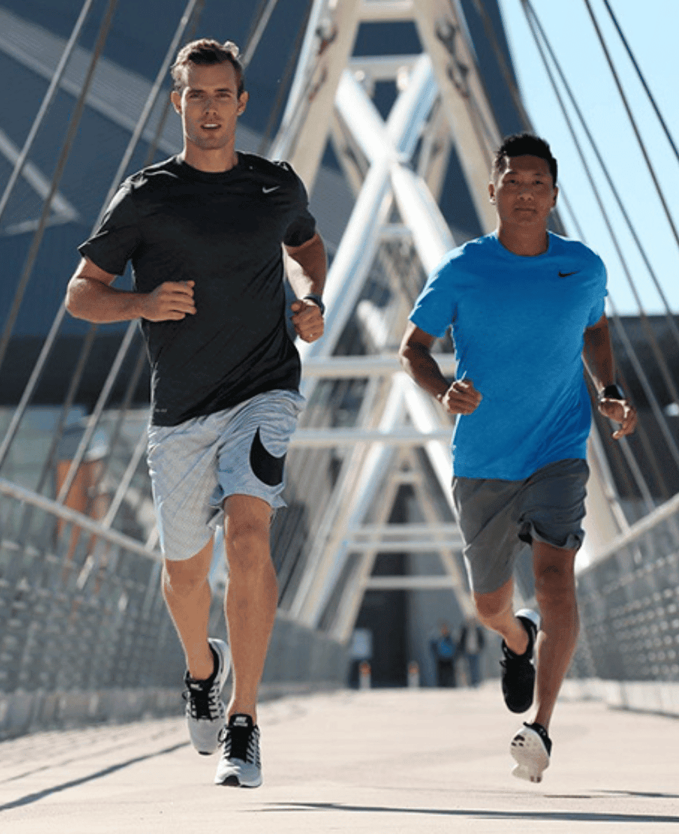 Running enthusiasts on modern urban bridge, active lifestyle, fitness and sports.