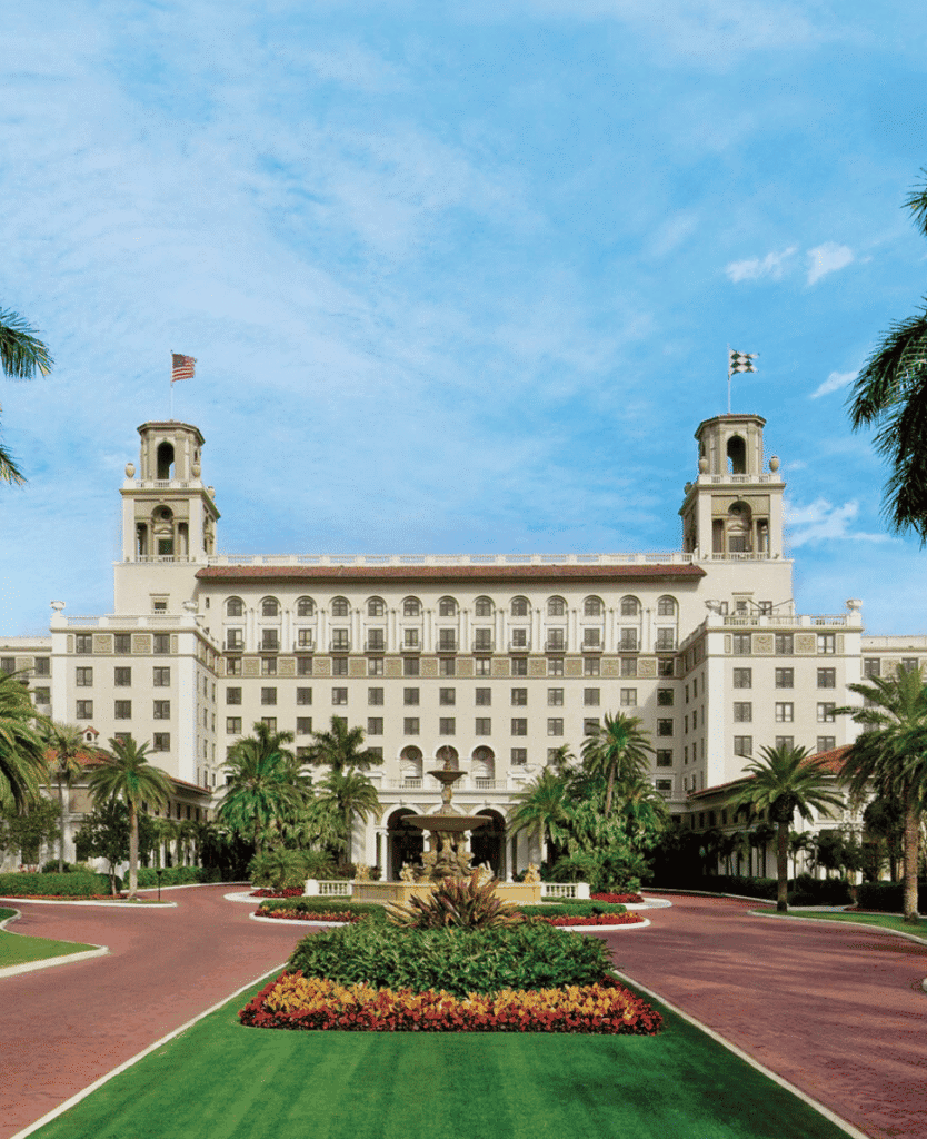 Luxury hotel in palm beach with lush landscaping and grand architecture.