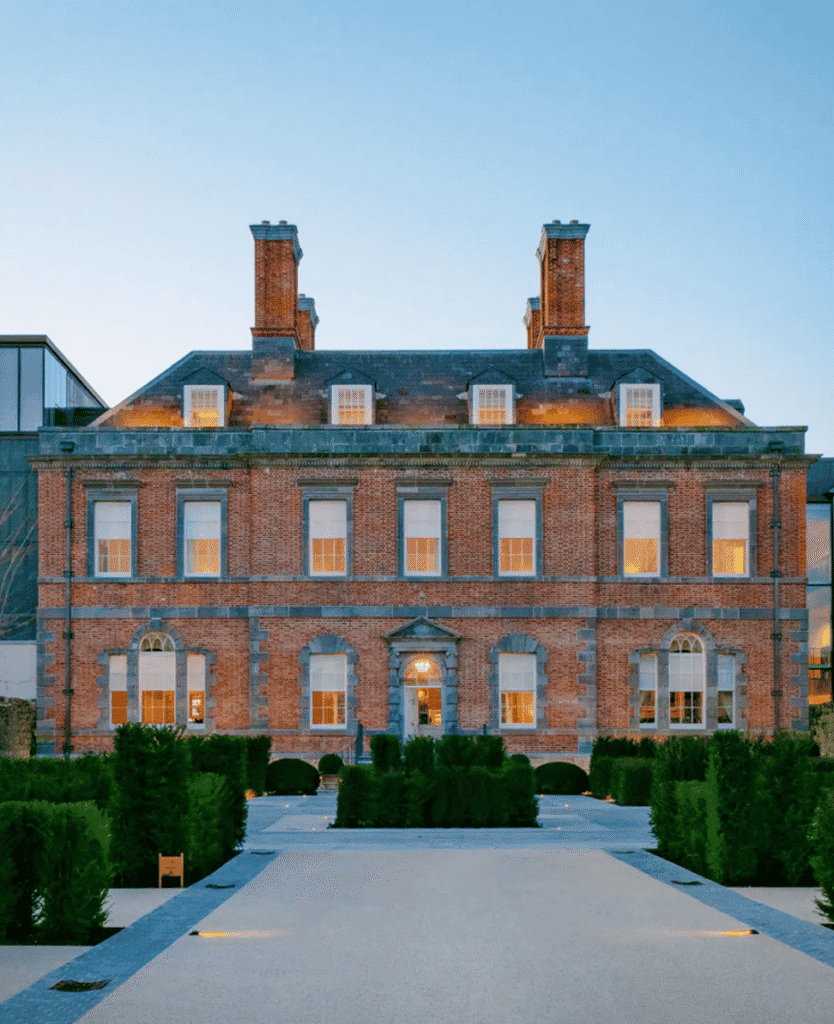 Luxury historic brick building with modern glass extension for wellness and spa treatments alternative health and beauty venue detailed exterior view of wellness retreat or spa facility relevant for luxury wellness and spa SEO.