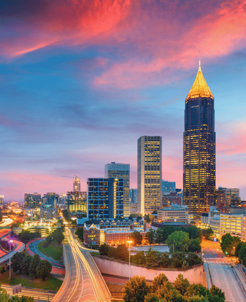 Skyline of Atlanta downtown at sunset with high-rise buildings and colorful clouds.