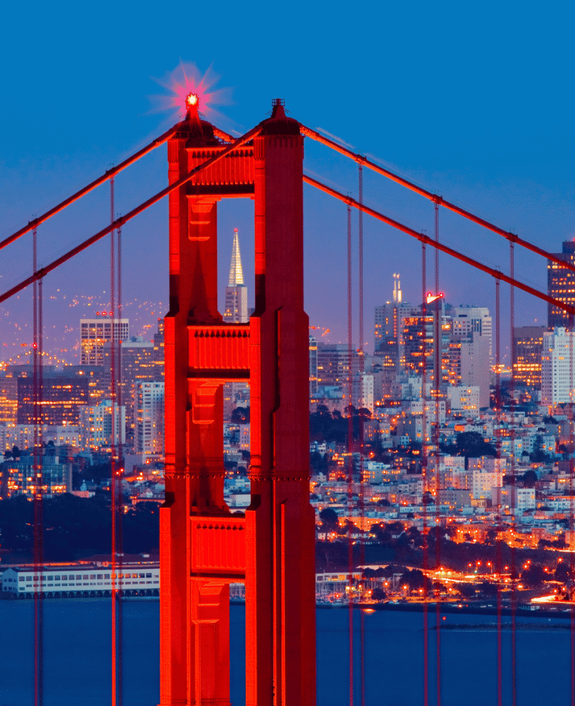 Golden Gate Bridge at dusk in San Francisco, illuminated with vibrant red lights.