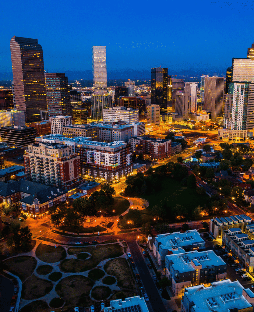 City skyline at night with illuminated skyscrapers and urban park, vibrant cityscape, modern architecture, downtown Los Angeles, California.