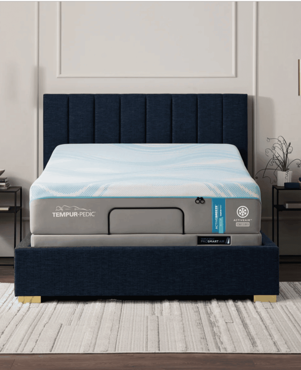 Tempur-Pedic mattress on navy upholstered bed with nightstands and modern decor.