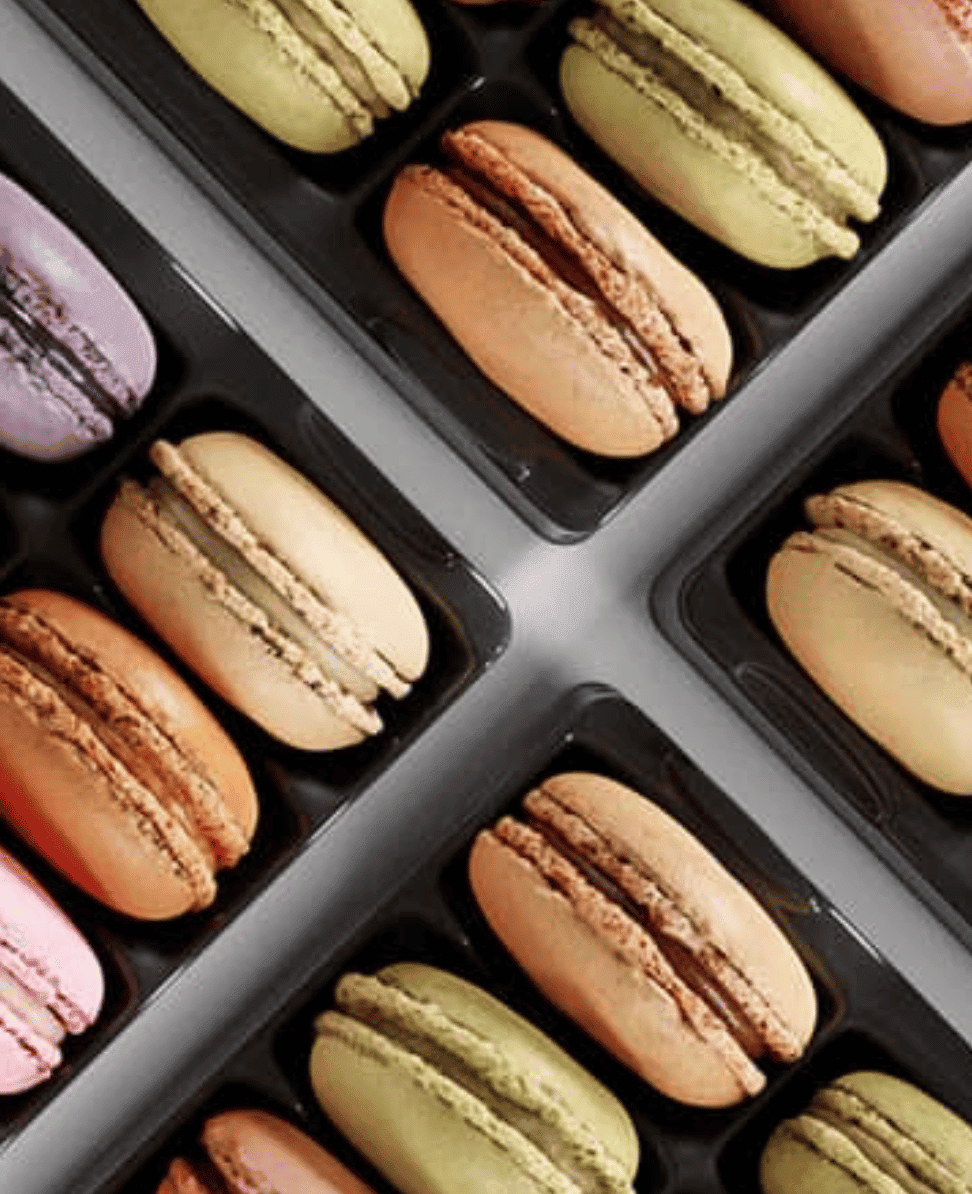 Delicious pastel macarons in variety of colors in a gift box, gourmet French pastries, sweet treats, luxury dessert selection.