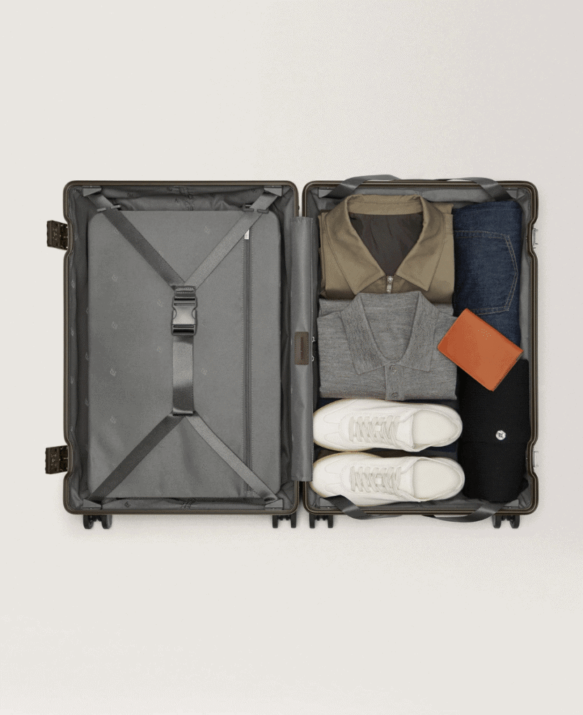 Neatly packed travel suitcase with clothing, shoes, and accessories for stylish packing.