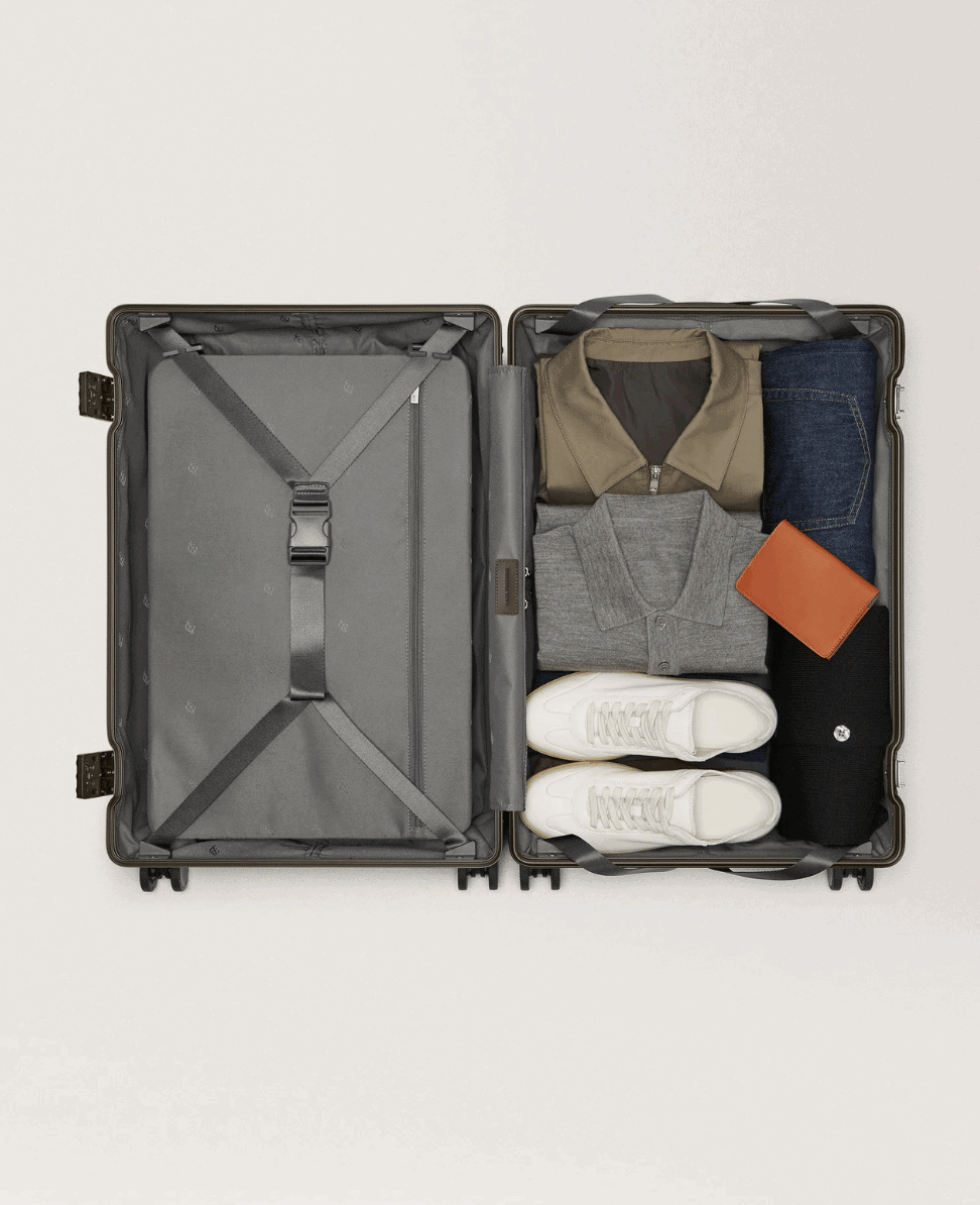 Neatly packed travel suitcase with clothing, shoes, and accessories for stylish packing.